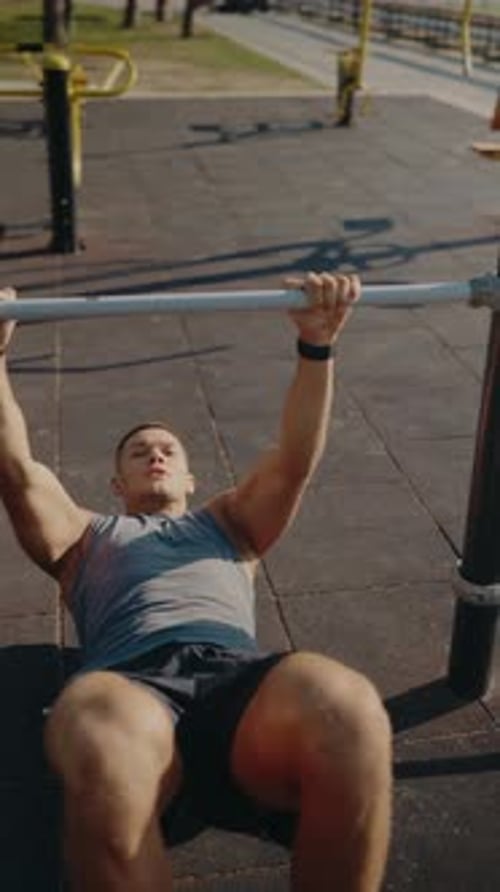 Athletic Man Exercising in Outdoor Gym with PullUp Bar Focused Workout