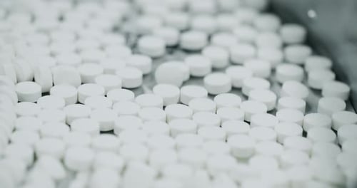 White Pills Moving on Metal Automatic Line in Workshop of Pharmaceutical Factory