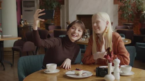 Young Women Taking Selfie Together in Restaurant