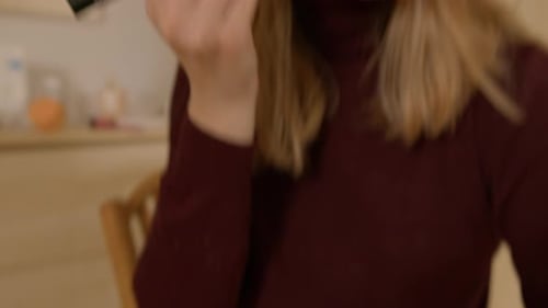 Woman Applying Makeup with Brush Indoors