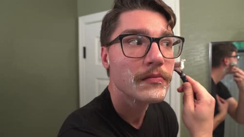 Man Shaving Mustache with Razor in Bathroom