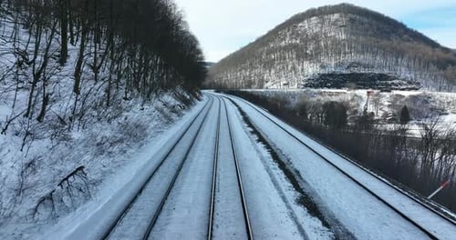 Train conductor engineer point of view POV shot. Train travel in winter snow mountain pass. Smooth g