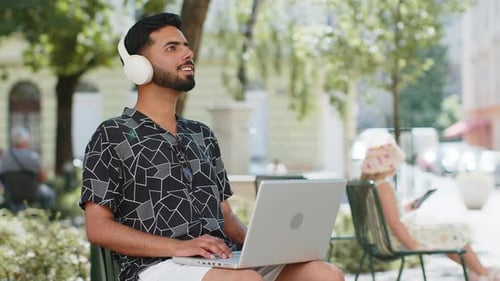 Young Adult Working on Laptop in City Park