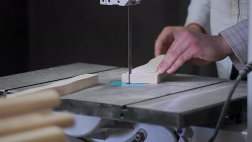 A man works with wood in a workshop. Working with wooden blanks. A man drills holes in wooden blanks