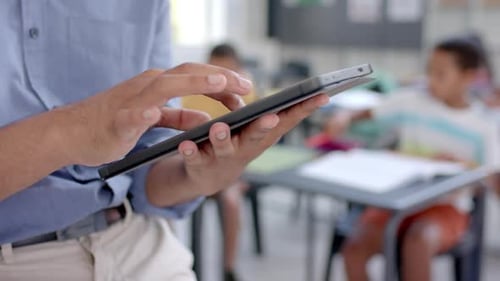 Teacher using a tablet in a school classroom