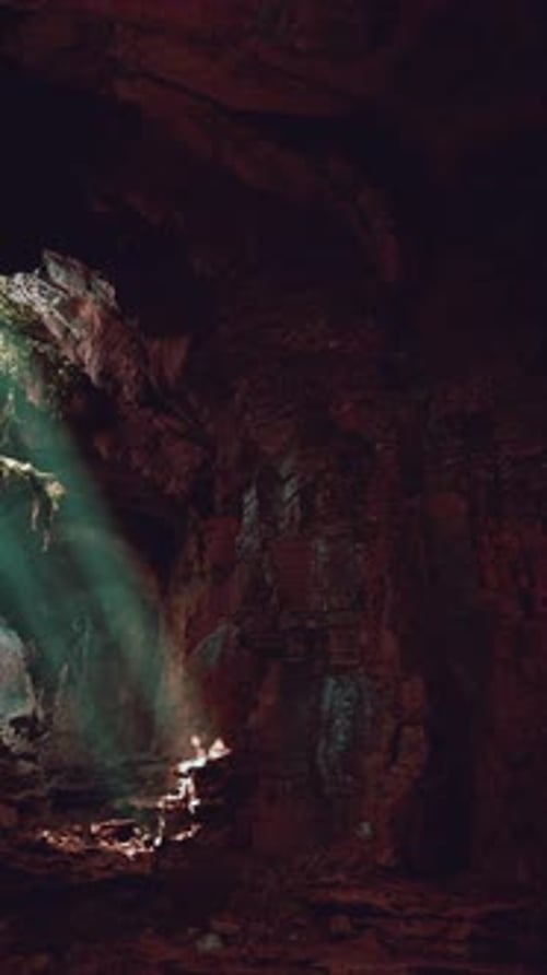 A Mesmerizing Green Light Shining Through the Entrance of a Mystical Cave