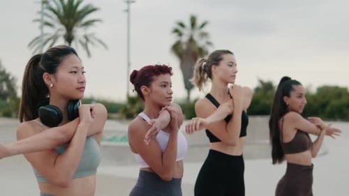 Four Women Stretching Arms Outdoors