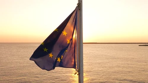 Flag Waving at Golden Hour Ocean Backdrop