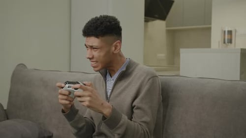 Intense Young Adult Gamer on Couch Plays Video Games