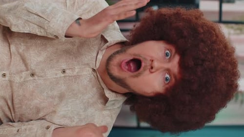Man with Afro Wig Expressing Shock and Surprise
