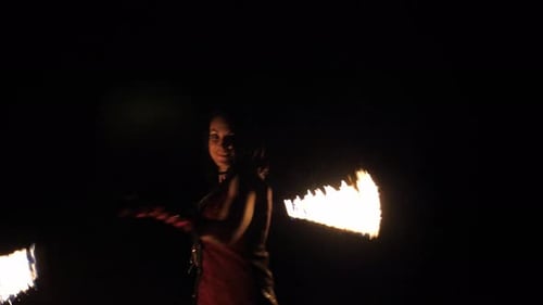 Woman Performing with Fiery Poi at Night