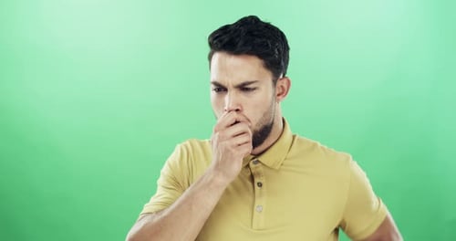 4k video footage of a young man coughing against a green studio background