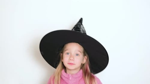 Girl Wearing Witch Hat Smiling at Camera