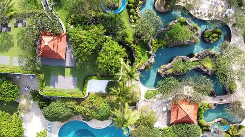 Aerial - birdseye shot of beautiful resort with pools and waterslides surrounded by lush jungle