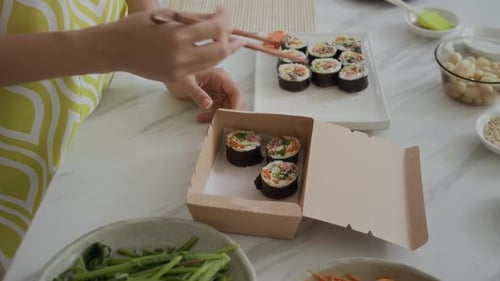 Woman Placing Kimbap in Box for Takeaway