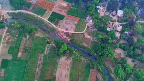drone shot of green farmland and houses