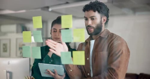 Business people, thinking or planning with tablet for brainstorming on glass board at office