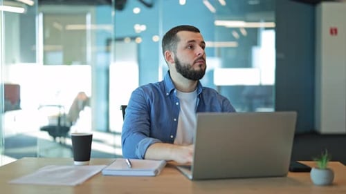 Focused Man Using Laptop In Modern Office For Productive Work