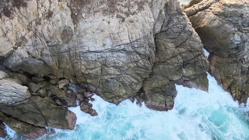 Jib up in zenith view above cliff and waves at sunrise in Oaxaca's shore