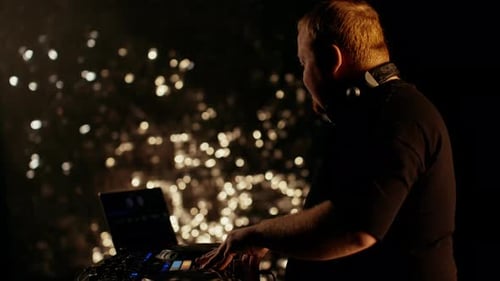 DJ Performing Music at a Nighttime Event