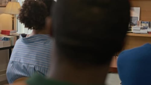 Adults Discussing a Book at a Table
