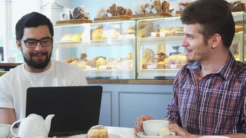 Young People Enjoying Lively Conversation Over Coffee at a Cozy Cafe