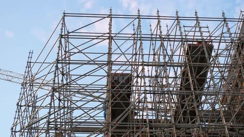 Grúa que opera en un sitio de construcción con una compleja red de andamios
