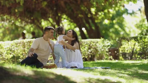Happy Family Enjoying Picnic in Green Park