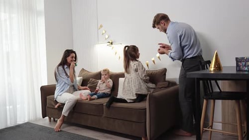 Family Celebrates Birthday Together on Couch at Home