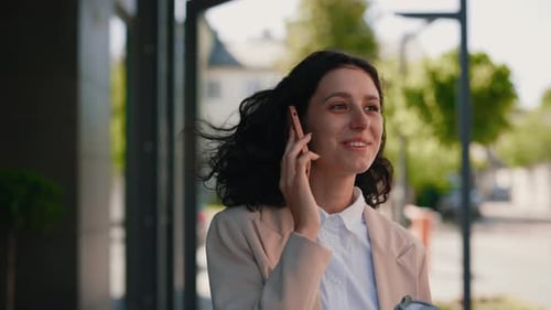 Woman Talking on Phone Walking near Building