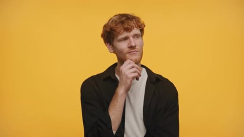 Cara atencioso considerando opções em fundo amarelo