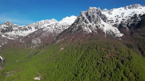 Erstaunliches Alpenpanorama mit hohen Gipfelbergen bedeckt mit weißem Schnee und grünem Wald unter blauem s