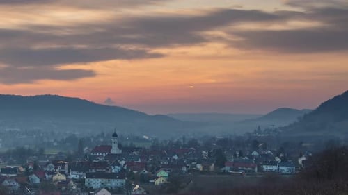Sol de tarde sobre el río Rin y un pequeño pueblo europeo con naturaleza de montaña