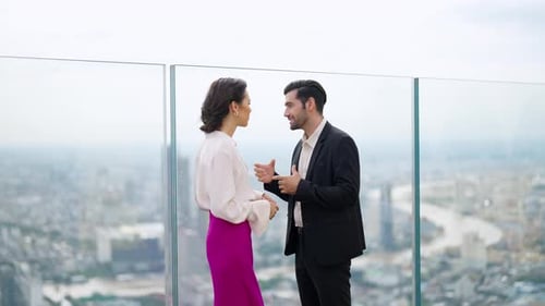 4K Caucasian businessman and businesswoman discussion business project at skyscraper office rooftop.