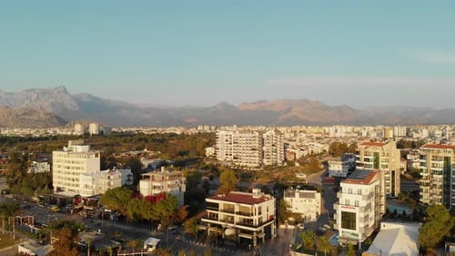 Camera Flies Over the Roofs of Houses in the Southern City Towards the Mountains