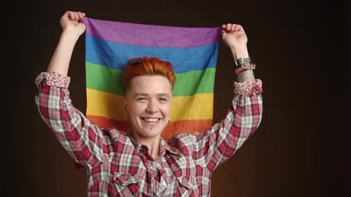 Smiling Adult Holding a Pride Flag