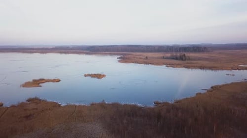 Revealing shot of a frozen lake in a rural European country during winter
