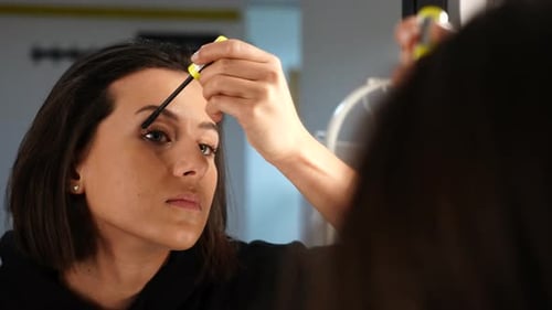 Beautiful Young Woman Adding Mascara on Eyelash in Front of Mirror, Close Up