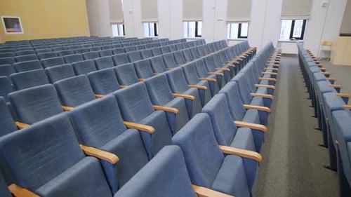 La salle de réunion comprend des sièges de théâtre rembourrés en velours