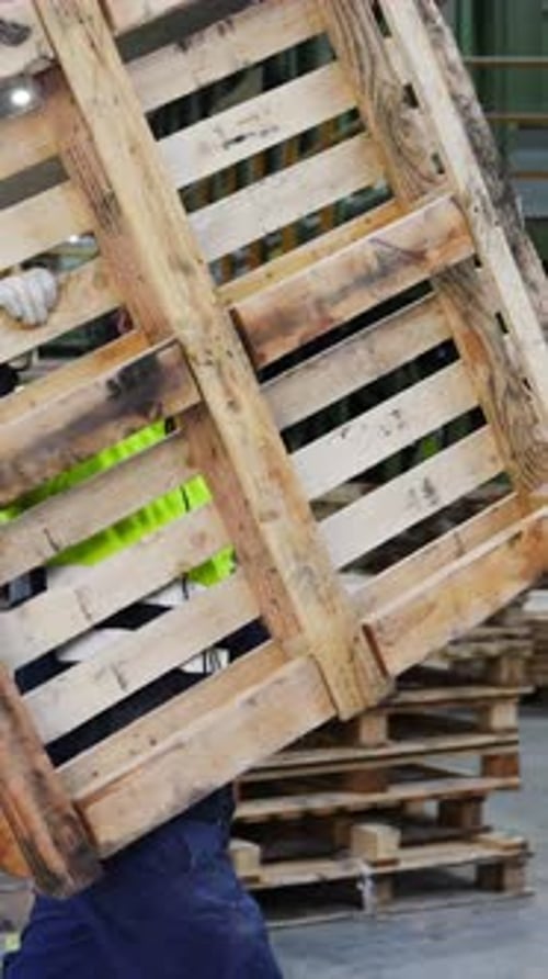 Factory Worker Handling Wooden Pallets in Slow Motion