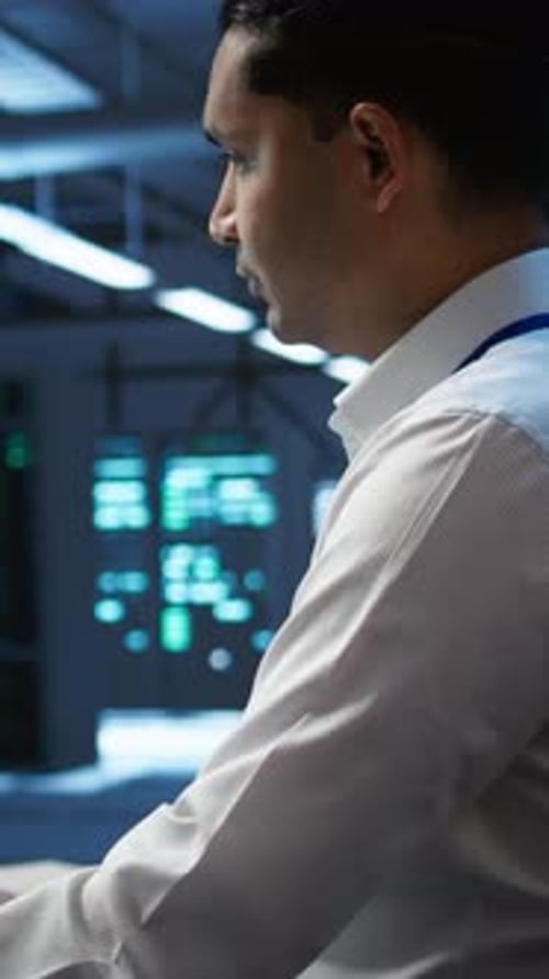 Vertical Video Portrait of Smiling Technician in Data Center Managing Infrastructure