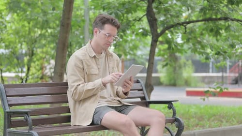 Modern Young Man using Tablet Outdoor