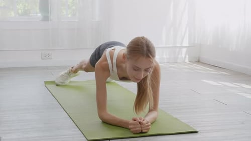 Woman Doing Twisting Plank Exercise on Yoga Mat