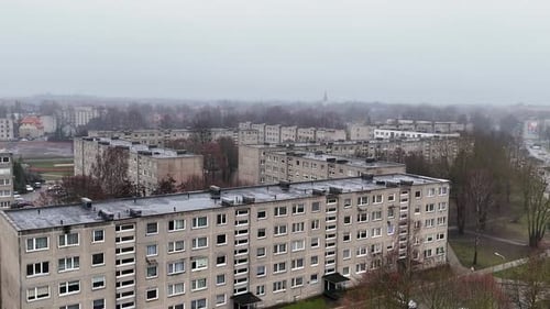 Rising, establishing drone shot of block building district in cold winter day without snow.