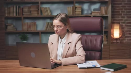 Smiling Woman Works at Desk in Office
