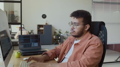 Portrait of Young Male Developer Working on Software Code in Office