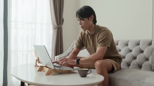 Young Adult Working on Laptop at Home