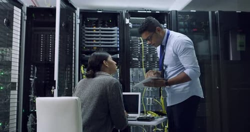 Man Consults with Woman in Server Room