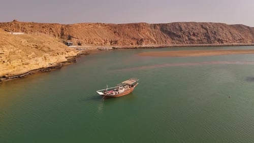Aerial view of a traditional dhow boat in the coastal waters of Oman.