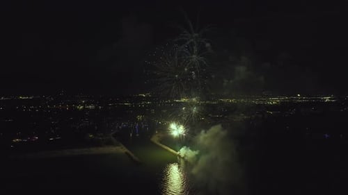 Vista aérea de fogos de artifício brilhantes explodindo com luzes coloridas sobre a costa do mar no Dia da Independência dos EUA